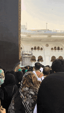 a crowd of people are standing in front of a large building
