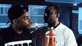 two men are standing next to each other with one wearing a shirt that says tnt on it