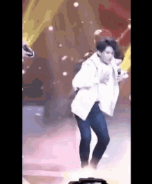 a man is dancing on a stage with a microphone .
