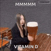 a woman is holding a large glass of beer .