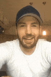 a man with a beard wearing a hat and a white shirt