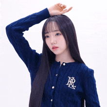 a woman wearing a purple sweater with the letter r embroidered on the front