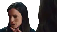a woman with long dark hair is looking at herself in the mirror
