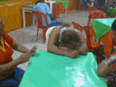 a woman sits at a table with her head on the table