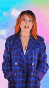 a woman with red hair is wearing a blue plaid jacket and necklace .