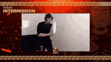 a man wearing headphones is holding a pillow in front of a screen .