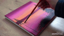 a person is painting a sunset on a canvas with the words made in animotica below it