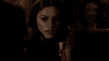 a close up of a man 's face in a dark room talking to another man .