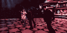 a group of people are dancing on a checkered floor with a sign that says gigigx on it