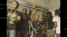 a group of young men are standing next to each other in a room and posing for a picture .