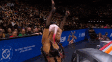 a woman with pink hair is standing in front of a aew banner