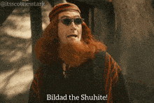 a man with red hair and sunglasses says " bildad the shuhte "