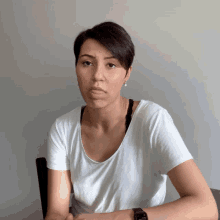 a woman wearing a white t-shirt and a black watch