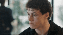 a young man with curly hair has a tattoo on his forehead that reads sgp