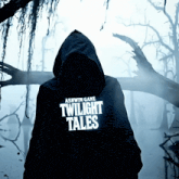 a person in a twilight tales hoodie stands in a foggy forest