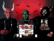 a group of devils are standing around a table with a laptop that has a sticker on it that says " evil "