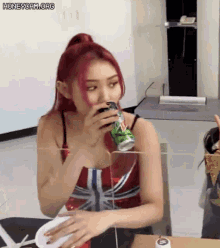 a woman with red hair is drinking from a can of mountain dew .