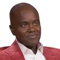 a man wearing a red jacket and a white shirt looks at the camera