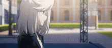 a girl with white hair is standing in front of a microphone in front of a building