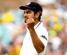 a man wearing a hat and a white shirt is making a funny face .
