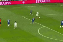 a group of soccer players are playing a game on a field sponsored by lidl .