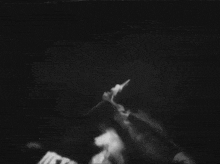 a black and white photo of a person flying through the air with the words flying in the background .