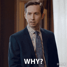a man in a suit and tie says " why "