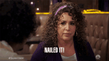 a woman with curly hair says nailed it in front of a man