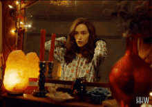a woman is looking at herself in a mirror with the letters hw on the bottom