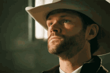 a man with a beard wearing a white hat