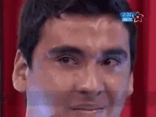a close up of a man 's face with the time 2:32 on the screen