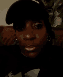 a woman wearing a hat and earrings is laying down