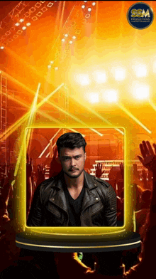 a man in a leather jacket stands in front of a crowd at a concert sponsored by gsm