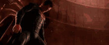 a person is holding a light saber in a dark room with a red light coming out of it .