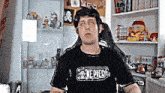 a man wearing a black one piece t-shirt is sitting in a chair