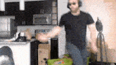 a man wearing headphones and sunglasses is dancing in a kitchen
