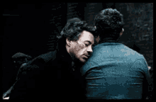 two men are standing next to each other and looking at each other .