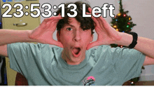 a young man making a face with his hands and the time 23:53:13 left