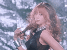 a woman with long pink hair is wearing a black tank top and silver bracelets