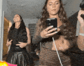 a woman taking a picture of herself with a cell phone