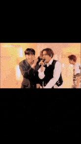 a group of young men are dancing and singing in front of a billboard sign