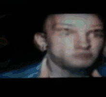 a blurry picture of a man 's face with a blue jacket on