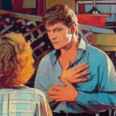 a man in a blue shirt is holding another man 's chest
