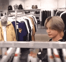a man in a store looking at a shirt that says aec on it