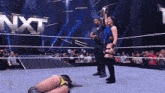 a woman in a wrestling ring with a nxt logo behind her