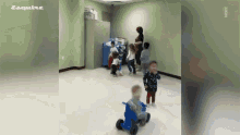 a group of children are playing in a room with esquire written on the bottom left
