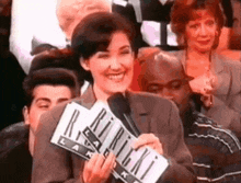 a woman is smiling while holding a sign that says ' r.i.p. '