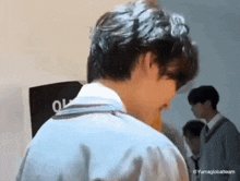 a close up of a person 's back with a group of people standing behind him .