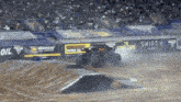 a monster truck is driving down a dirt track in front of a shift 4 banner