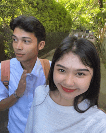 a man and a woman are standing next to each other on a path